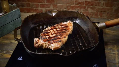 Cooking beefsteak. One beef fillet meat is being fried in a broiler pan. 4K Stock Footage 84251193