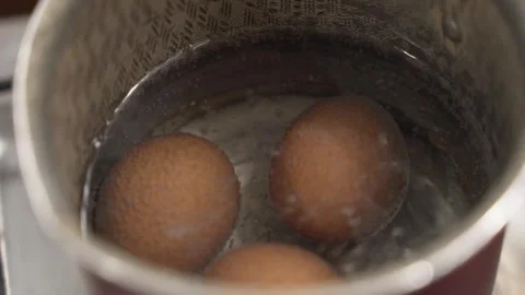 Cooking boiled eggs. Brown eggs in hot water Stock Footage 345154694