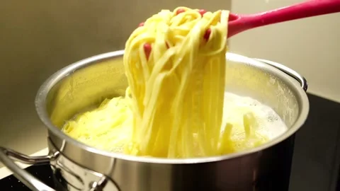 Cooking (boiling) pasta tagliatelle in a pot of boiling water Stock Footage 310520904