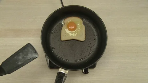 Cooking of breakfast with fried egg and toast Stock Footage 73949083