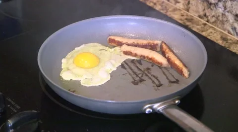 Cooking breakfast sausage and eggs Stock Footage 44259490