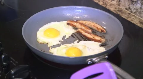 Cooking breakfast sausage and eggs 02 Stock Footage 44259491