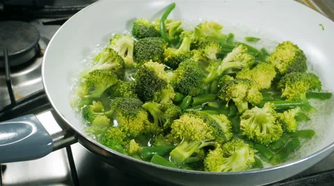 Cooking broccoli and green beans in a frying pan Stock Footage 57531877