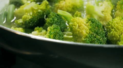 Cooking broccoli and green beans in a frying pan. Slider video. Stock Footage 57533192