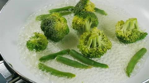 Cooking broccoli and green beans in a frying pan Stock Footage 57534073