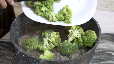 Cooking broccoli with beef in a black pot, close up Stock Footage 154283855