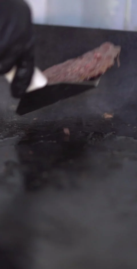 Cooking burgers on a griddle Stock Footage 240873795