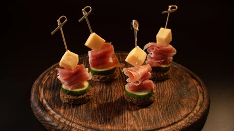 Cooking canapes, bread, cheese, jamon, ham, cucumber, canapes on skewers Video stock 148620125