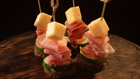 Cooking canapes, bread, cheese, jamon, ham, cucumber, canapes on skewers rotates Stock Footage 148626123