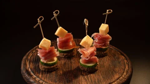 Cooking canapes, bread, cheese, jamon, ham, cucumber, canapes on skewers Video stock 148630016