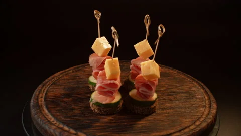 Cooking canapes, bread, cheese, jamon, ham, cucumber, canapes on skewers Video stock 148632205