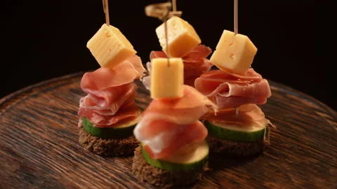 Cooking canapes, bread, cheese, jamon, ham, cucumber, canapes on skewers rotates Stock Footage 148635436