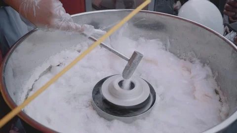 Cooking candy floss closeup. Young female hands in gloves wrap sugar on a stick. Stock Footage 116443259