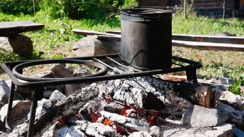 Cooking in a cauldron on a campfire in nature Video stock 136779046
