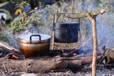 Cooking with cauldron on campfire. Stock Photos