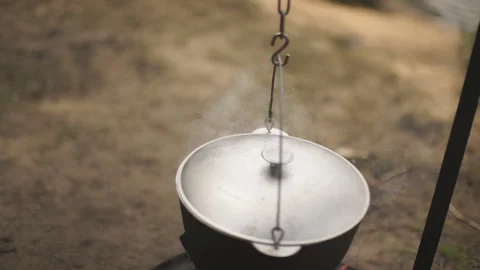Cooking in a cauldron on an open fire. Preparing food at the stake in a camping. Stock Footage 92450125
