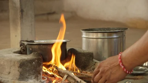 Cooking chai on an open fire using sticks as fuel, India. Stock Footage 95548860
