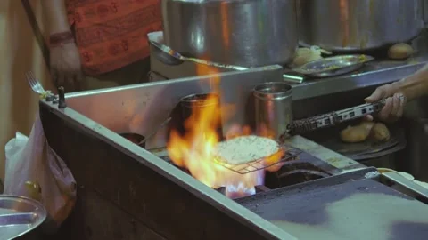 Cooking chapatis. An Indian flatbread is baked on the fire Stock Footage 160403375