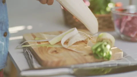 Cooking - Chef's hands are peeling white radish in the kitchen. Stock Footage 242343129
