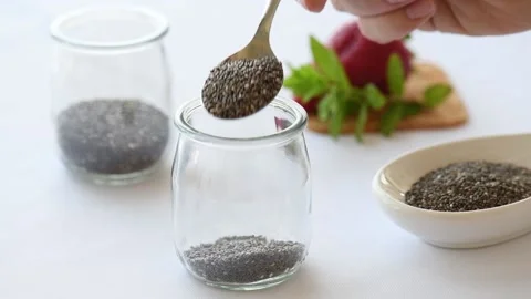 Cooking Chia Pudding: Putting Chia Seeds in a jar Stock Footage 139925021