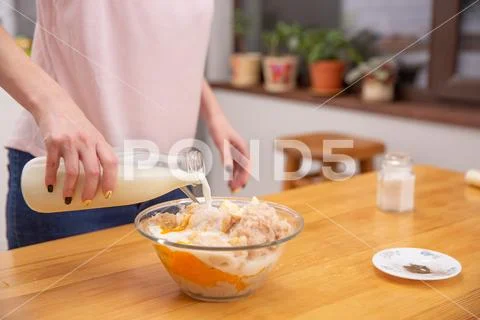 Cooking chicken sausages. pouring milk to minced chicken Stock Photos