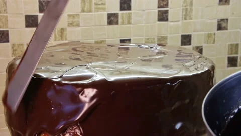 Cooking chocolate cake. Biscuit cake soaked in apricot jam rotates on a stand. Stock Footage 170999573