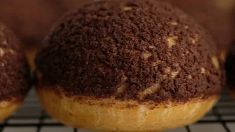 Cooking choux or profiteroles, ready choux on wire rack, close-up. Cooking Stock Footage 145491566