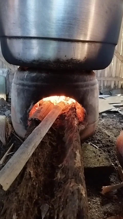 Cooking on a clay stove or earthenware stove, with a wood fire Stock Footage 310866878