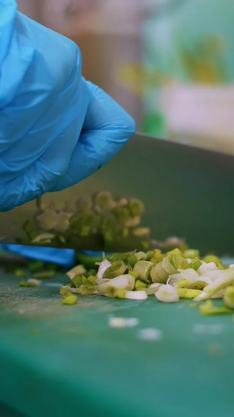 Cooking. close-up, the chef, in protective gloves, is cutting green onion on Stock-Footage 319772007