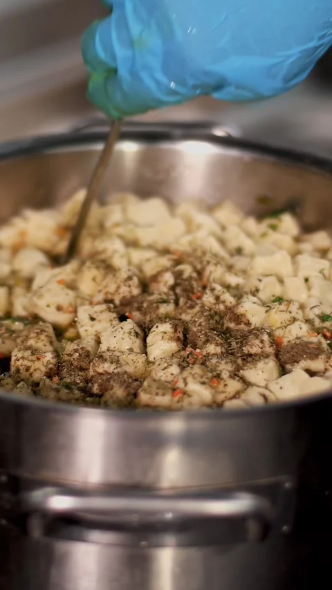 Cooking. close-up. the chef, in protective gloves, put spices in soup and stirs Stock Footage 319992373