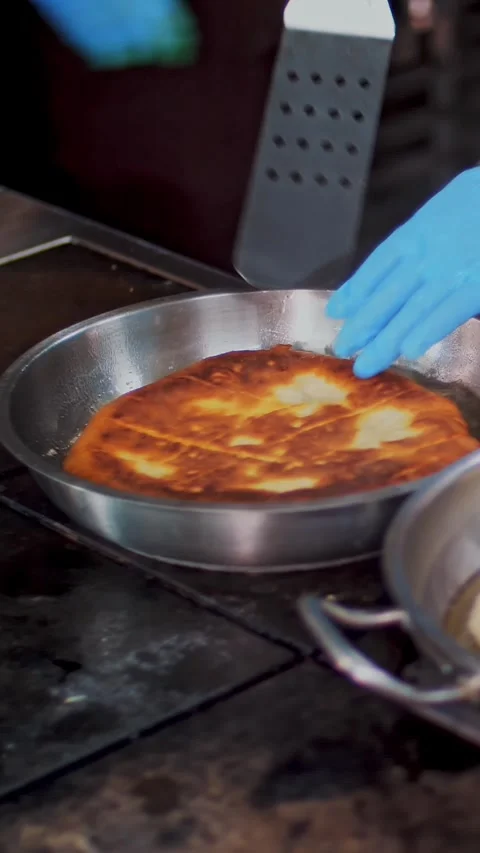 Cooking. close-up. chef, in protective gloves, fries a large tortilla, pita Video stock 321534206