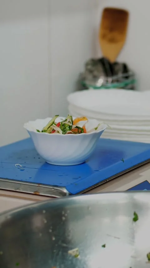 Cooking. close-up. the cook, in protective gloves, puts vegetable salad into Stock Footage 323088642