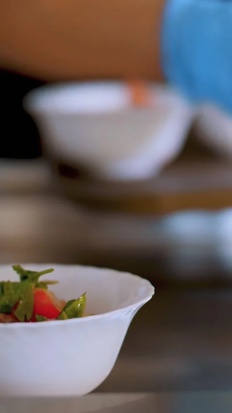 Cooking. close-up. waiter, in protective gloves, puts bowls of salads to Video stock 322978978