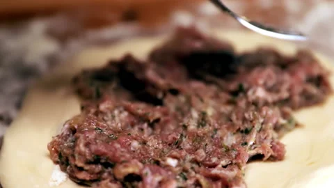 Cooking. The cook puts minced meat on the dough. Pies with meat. Cheburechna Video stock 180659634