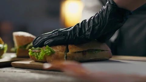 Cooking, cooking master Cuts a crispy sandwich with a knife in an authentic Stock Footage 246207241