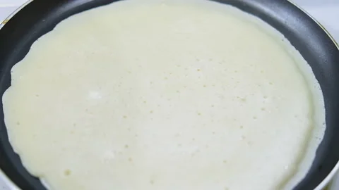 Cooking crepes. Thin pancake is fried in pan. Traditional food for Mardi Gras Stock Footage 220200141