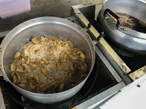 Cooking "crispy, deep-fried chicken skin" in stainless pot. Stock Photos