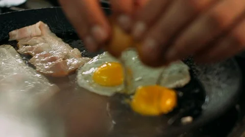 Cooking Delicious Fried Eggs with Bacon in Pan. Stock Footage 115564060