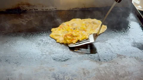 Cooking Delicious Stir-fried Egg and Shrimp Omelette on a Hot Griddle Video stock 331565732