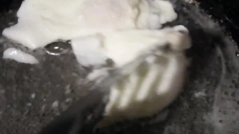 In this cooking demonstration, an egg is being poached in a pan, highlighting Stock Footage 292751631