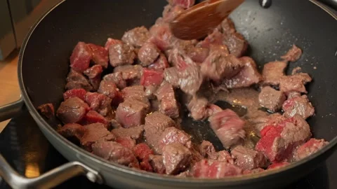 Cooking Diced Beef in a Deep Frying Pan Stock Footage 303934012
