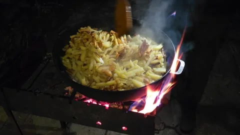 Cooking dinner - fried potatoes in a cast iron skillet on the grill Stock Footage 243716538