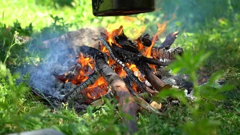 Cooking dinner or tea with open fire. Burning firewood and smoke. Halt and rest  Stock Footage 112803626