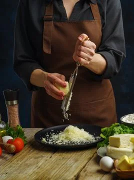 Cooking dishes using cheese by the hands of a professional chef. The chef gra Stock Photos