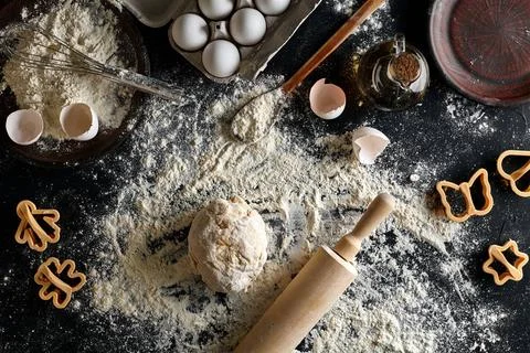 Cooking dough for cookies, butter, eggs, cooking equipment, flour on a bla... Stock Photos