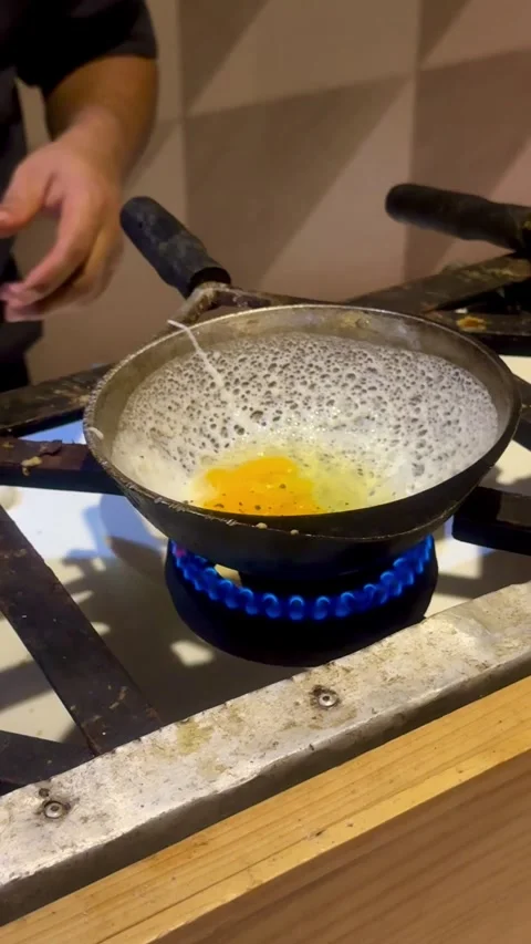 Cooking Egg on Gas Stove in Rustic Kitchen Video stock 314884372