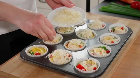 Cooking egg muffins with vegetables and cheese in the oven. Stock Footage 253549504