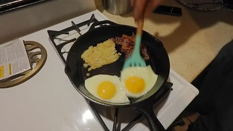 Cooking eggs, bacon and potatoes for breakfast Stock Footage 162534247