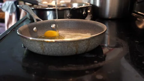Cooking eggs in a pan side view slow motion 库存影片 280143480
