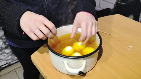 Cooking eggs in a pot while preparing a meal in a small kitchen Stock-Footage 328441203